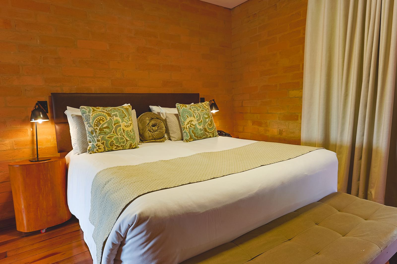 Suíte Deluxe Janela com cama queen e tijolo aparente